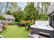 Relaxing backyard area featuring a hot tub, outdoor dining set, artificial turf, and privacy fence at 11550 Clarkston Rd, Zionsville, IN 46077