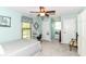 Well lit bedroom features a light blue color scheme, ceiling fan, and a quaint seating area in the hallway at 11550 Clarkston Rd, Zionsville, IN 46077