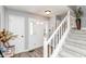 Inviting foyer featuring a beautiful staircase and white front door and neutral decor at 11550 Clarkston Rd, Zionsville, IN 46077