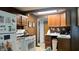 Functional kitchen with white appliances, wood cabinets, and a view of the dining area at 1202 S Ribble Ave, Muncie, IN 47302