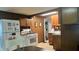 Functional kitchen with white appliances, wood cabinets, and a view of the dining area at 1202 S Ribble Ave, Muncie, IN 47302