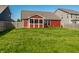Spacious backyard featuring a well-maintained lawn and a charming red home with a screened-in porch at 1221 Danielle Rd, Lebanon, IN 46052