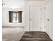 Bright entryway featuring wood-look flooring transitioning to carpet, leading to a spacious living area at 1221 Danielle Rd, Lebanon, IN 46052