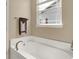 Bathroom features a white soaking tub under a window with a neutral colored wall at 1401 Blackthorne N Trl, Plainfield, IN 46168