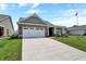 Charming brick home featuring a two-car garage and a welcoming front porch at 1401 Blackthorne N Trl, Plainfield, IN 46168