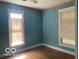 Blue bedroom with hardwood flooring and natural light streaming through two windows at 1440 E Morgan E St, Martinsville, IN 46151