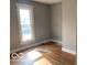Hardwood flooring is present in the bedroom that features gray walls and a single window at 1440 E Morgan E St, Martinsville, IN 46151