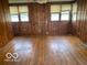 Spacious living room with hardwood floors, wood paneling, and plenty of natural light from the windows at 1440 E Morgan E St, Martinsville, IN 46151