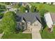 Stunning aerial view of the brick home with a well-maintained lawn and mature trees at 1454 Woodfield Dr, Greenwood, IN 46143