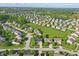 Expansive aerial view of the neighborhood with lush green spaces and a pond at 1454 Woodfield Dr, Greenwood, IN 46143