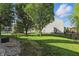 Spacious, fenced backyard with mature trees and lush green grass at 1454 Woodfield Dr, Greenwood, IN 46143