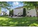 Large backyard with a stone patio, a hot tub, seating, and lush green grass at 1454 Woodfield Dr, Greenwood, IN 46143