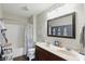 Bathroom with double vanity, shower with curtain, and decorative mirror at 1454 Woodfield Dr, Greenwood, IN 46143