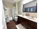 Bright bathroom features double sink vanity, tub/shower combo with stylish curtain, and wood-look flooring at 1454 Woodfield Dr, Greenwood, IN 46143