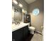 This half bath features a charming octagonal window and a modern vanity with black hardware at 1454 Woodfield Dr, Greenwood, IN 46143