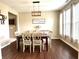 Cozy dining room features a wood table, stylish chandelier, and abundant natural light from the large windows at 1454 Woodfield Dr, Greenwood, IN 46143