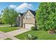 Attractive brick home featuring a well-kept lawn, mature trees, and a spacious two-car garage at 1454 Woodfield Dr, Greenwood, IN 46143