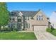 Beautiful two-story brick home featuring a well-manicured lawn and a two-car attached garage at 1454 Woodfield Dr, Greenwood, IN 46143