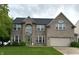 Charming two-story brick home with a green lawn, a two-car garage, and a beautifully landscaped front yard at 1454 Woodfield Dr, Greenwood, IN 46143