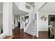 Spacious hallway featuring hardwood floors, neutral paint, and a staircase with white railings at 1454 Woodfield Dr, Greenwood, IN 46143