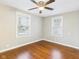 Bright bedroom with hardwood floors, ceiling fan, and two windows at 1505 E 30Th St, Anderson, IN 46016