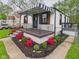 Home featuring a striped awning, wrought iron details, and lush landscaping at 1505 E 30Th St, Anderson, IN 46016
