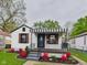 Charming home featuring a covered porch, striped awning, and well-manicured landscaping at 1505 E 30Th St, Anderson, IN 46016