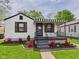 Charming home with a striped awning, landscaped flower beds, and a well-maintained lawn at 1505 E 30Th St, Anderson, IN 46016