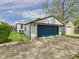 Detached garage with a large blue door and concrete driveway at 1505 E 30Th St, Anderson, IN 46016