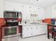 Kitchen with white cabinets, stainless steel appliances, tile floor and red accent wall at 1505 E 30Th St, Anderson, IN 46016