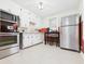 Compact kitchen with white cabinetry, stainless steel appliances, and an adjacent dining table with chairs at 1505 E 30Th St, Anderson, IN 46016