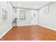 Bright living room with hardwood floors, white walls, and a front door to the porch at 1505 E 30Th St, Anderson, IN 46016
