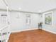 Bright and airy living room with hardwood floors, two windows, and a white front door at 1505 E 30Th St, Anderson, IN 46016