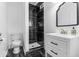 Sleek bathroom featuring black tile shower with modern fixtures and bright white vanity at 1505 Spann Ave, Indianapolis, IN 46203