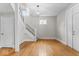 Bright living room features wood floors, a staircase, and a modern light fixture at 1505 Spann Ave, Indianapolis, IN 46203
