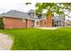 The backyard features a brick house with a large lawn, patio and exterior stairs at 1510 Continental Dr, Zionsville, IN 46077