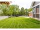Large backyard featuring mature trees and a white fence surrounding playground equipment at 1510 Continental Dr, Zionsville, IN 46077