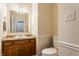 Cozy half bath with a wood vanity, a white sink, and a commode at 1510 Continental Dr, Zionsville, IN 46077