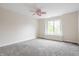 A bright bedroom with neutral walls, plush carpeting, and a large window with natural light and ceiling fan at 1510 Continental Dr, Zionsville, IN 46077