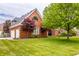 Two-story brick home featuring manicured lawn, mature trees, and attached garage at 1510 Continental Dr, Zionsville, IN 46077