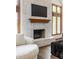 Close-up of the fireplace in the living room with hardwood floors and modern furnishings at 1510 Continental Dr, Zionsville, IN 46077