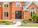 Close-up of the front door and entry of a brick two-story home with manicured shrubs at 1510 Continental Dr, Zionsville, IN 46077