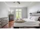 Well-lit main bedroom featuring wood floors, a ceiling fan, and views of lush landscaping at 1510 Continental Dr, Zionsville, IN 46077