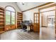 Well-lit home office with hardwood floors, built-in shelving, and a vaulted ceiling at 1510 Continental Dr, Zionsville, IN 46077