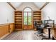 Comfortable home office with hardwood floors, built-in shelving, and a bright arched window at 1510 Continental Dr, Zionsville, IN 46077