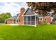 Expansive rear of home with screened-in porch, brick facade, lawn and a chimney at 1510 Continental Dr, Zionsville, IN 46077