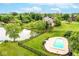 Aerial view of a large backyard with an in-ground pool, lush lawn, mature trees, and a serene pond at 16285 Remington Dr, Fishers, IN 46037