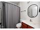 Well-lit bathroom featuring a shower with gray curtain, tile floors, and a wooden vanity with sink at 16285 Remington Dr, Fishers, IN 46037