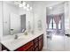 Bathroom featuring double sinks and a view into a bedroom with tray ceilings and natural light at 16285 Remington Dr, Fishers, IN 46037