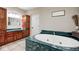 Bright bathroom with a large soaking tub, wooden cabinets, and double sinks with marble countertops at 16285 Remington Dr, Fishers, IN 46037